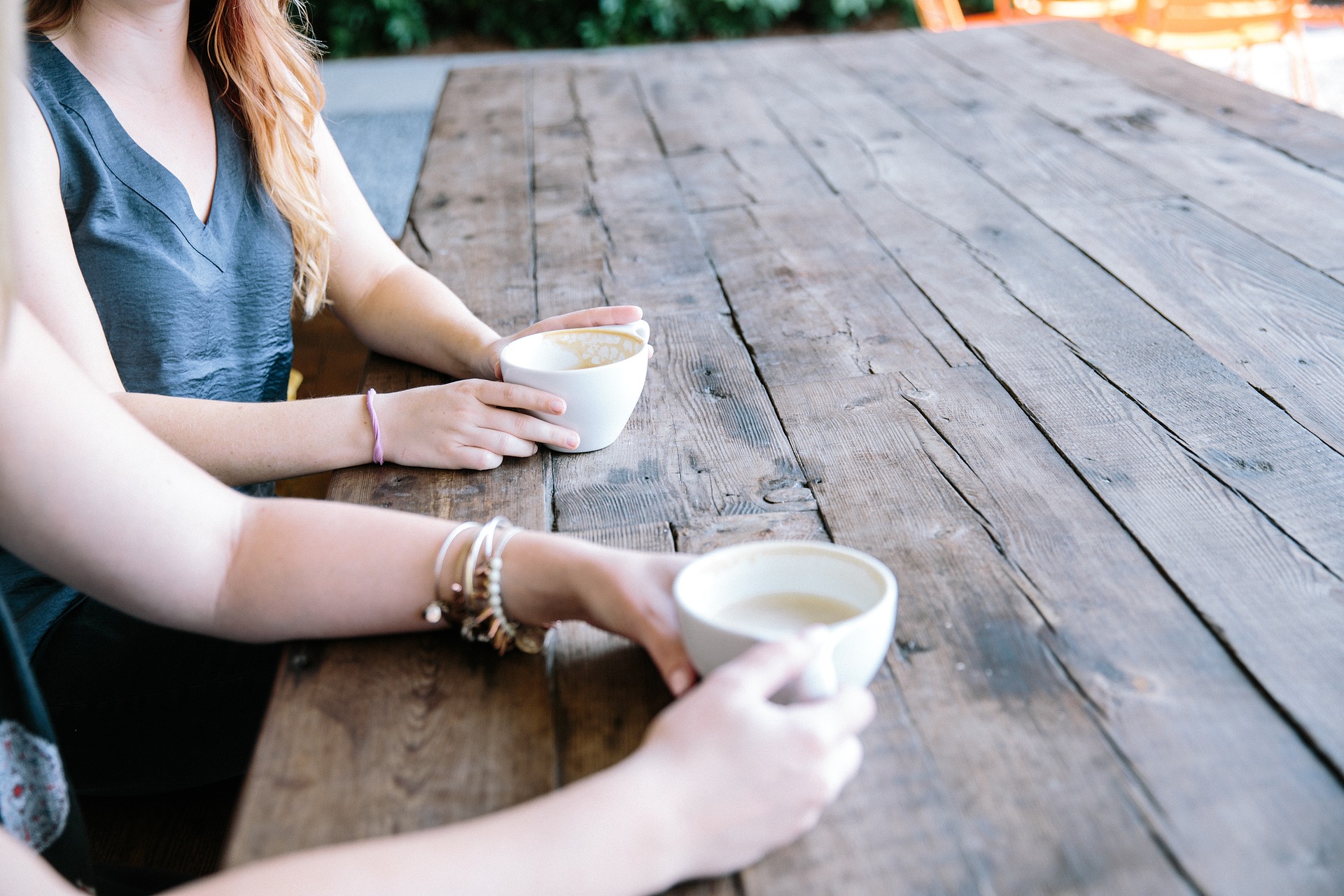 Two people sitting next to each with coffee cups. Stock photo.